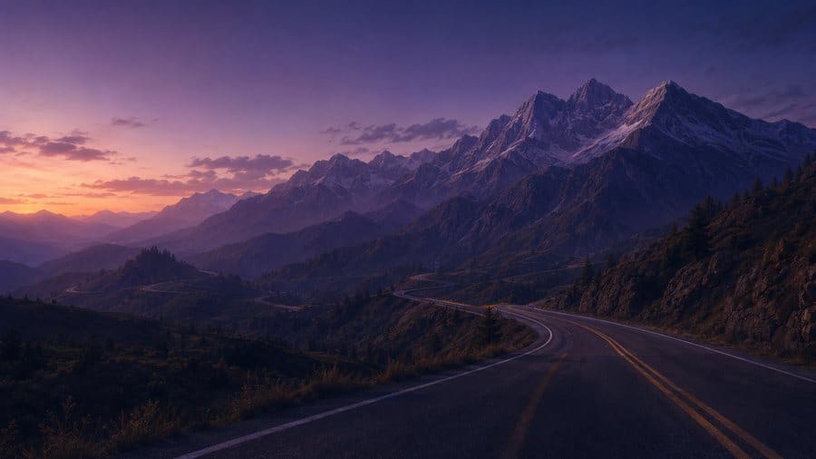 A mountain road winding into the distance at dusk.